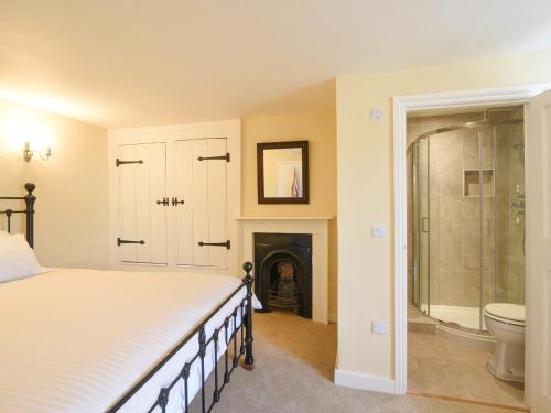 a bedroom with a bed and a bathroom with a fireplace at Malabar House in Lyme Regis