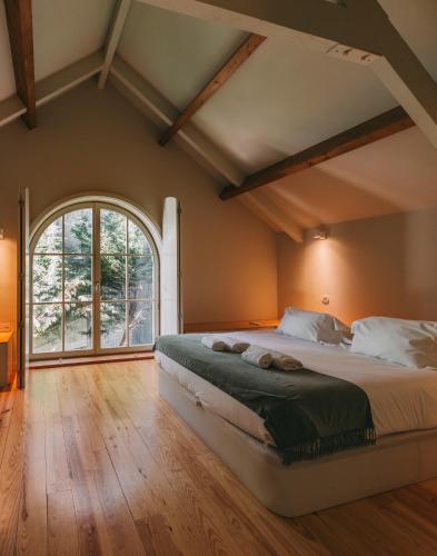 a bedroom with a large bed and a large window at Oporto Maison Palace in Porto