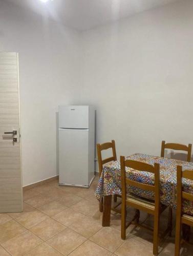a dining room with a table and a refrigerator at Casa vacanze paola in Porto Empedocle