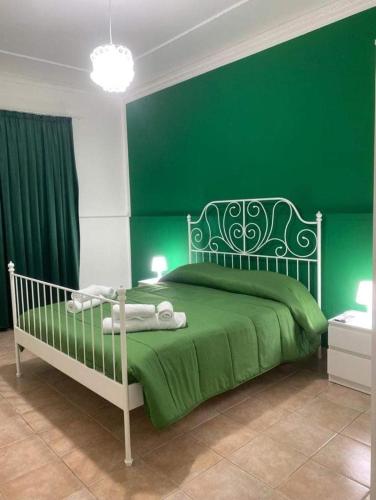 a green bedroom with a bed with a green wall at Casa vacanze paola in Porto Empedocle