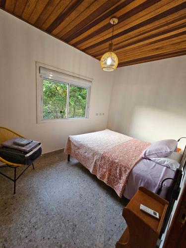 een slaapkamer met een bed en een raam bij Cabana do Rancho Roque Reis - Wine and Nature in Piedade