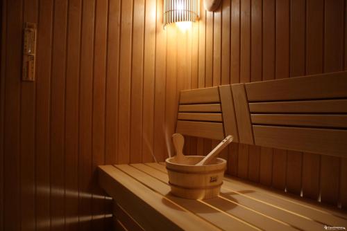 a wooden sauna with a bucket and two wooden spoons at Orom Hotel Fergana in Fergana