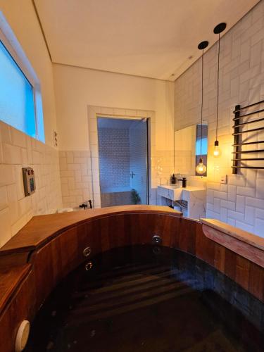 een badkamer met een dompelbad met een wastafel en een raam bij Cabana do Rancho Roque Reis - Wine and Nature in Piedade
