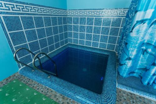 a blue tiled bath tub in a bathroom at Orom Hotel Fergana in Fergana