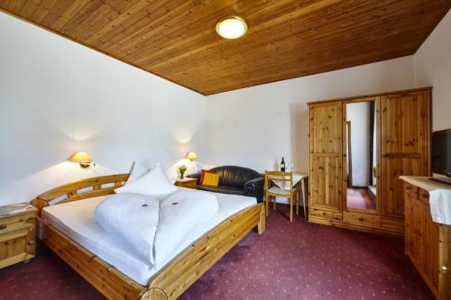 sypialnia z dużym łóżkiem i telewizorem w obiekcie Hotel Obermoosburg w mieście Coldrano