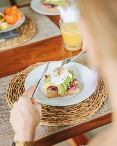 a person holding a plate of food on a table at The Jungle Loft Galle in Galle