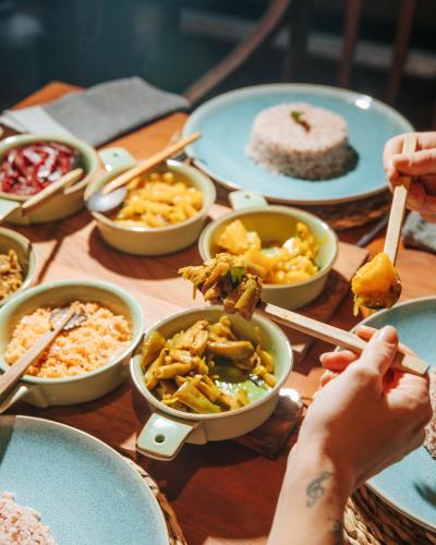a table topped with bowls of food and plates of food at The Jungle Loft Galle in Galle