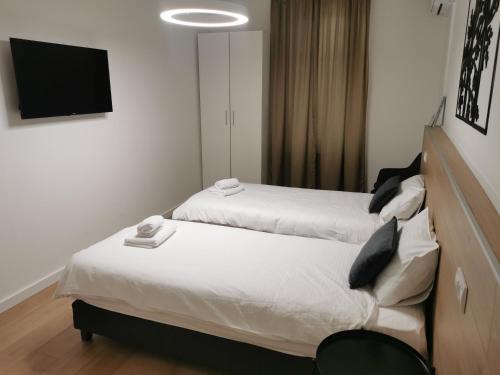 duas camas num quarto com uma televisão na parede em BG Exclusive Apartment em Belgrado