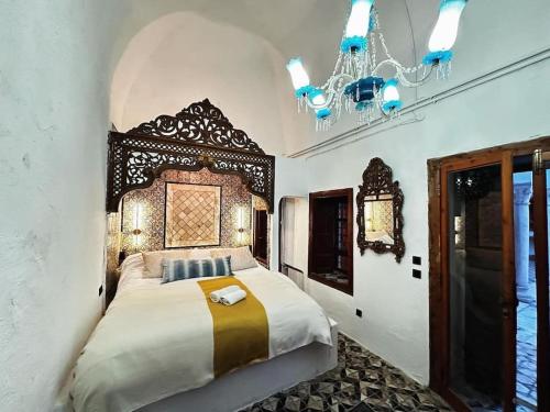 um quarto com uma cama e um lustre em Suite Noor B&B Pool SidiBouSaid em Sidi Bou Saïd