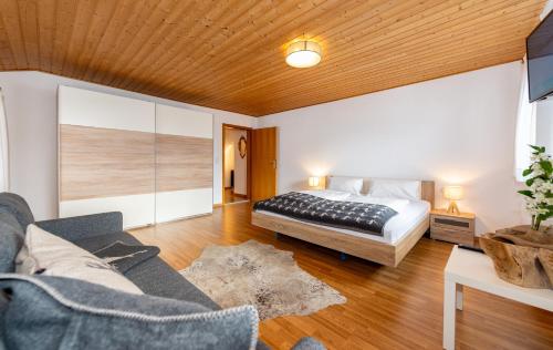 1 dormitorio con 1 cama y 1 sofá en Alpen Appartements Marlene en Ehrwald