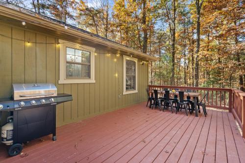 a deck with chairs and a grill on a house at Emerald Cabin W/Hot tub, Firepit, Lake, Skiing in Basye