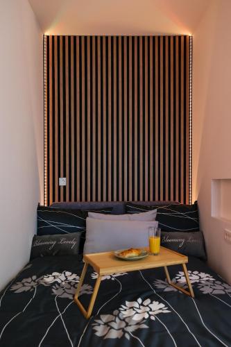 a coffee table with a plate of food on a bed at Modern Luxe Haven in Zagreb