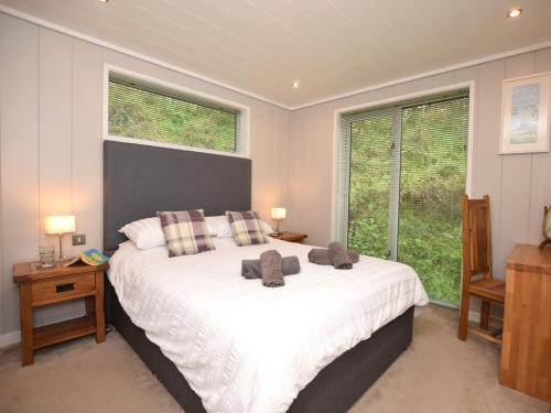a bedroom with a large white bed with two windows at 2 Bed in Conwy 60292 in Llangelynin