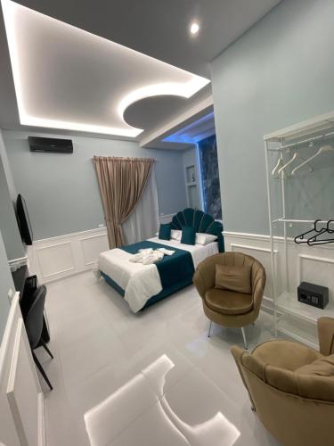 una camera con letto, divano e sedie di Sunny Suite Napoli a Napoli