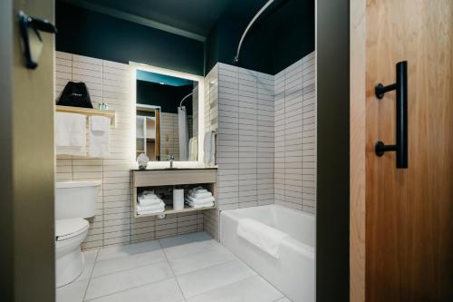 ein Badezimmer mit einer Badewanne, einem WC und einem Waschbecken in der Unterkunft Métis Crossing in Smoky Lake