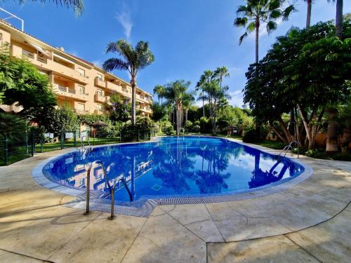 einen Pool in einem Resort mit Palmen in der Unterkunft SR Carib Playa Marbella in Marbella