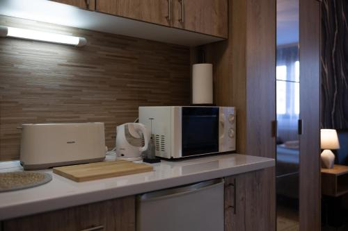 a kitchen with a microwave and a counter top with a appliance at T - Polis in Subotica