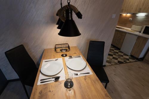 a dining room table with aendant light and a table and chairs at T - Polis in Subotica