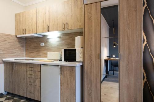 a kitchen with wooden cabinets and a microwave at T - Polis in Subotica