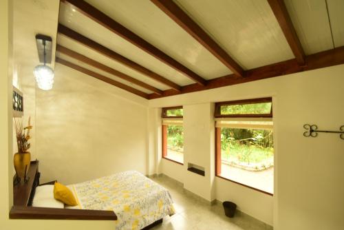 a bedroom with a bed and a window at Mindo MONASTERIUM in Mindo