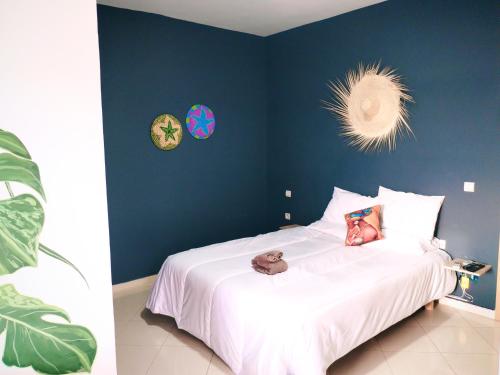 - une chambre avec un grand lit blanc aux murs bleus dans l'établissement Large Sea view studio, à Agadir
