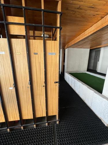 a row of wooden lockers in a room at Appartement Tignes 2100 - 6-8 personnes - 2 chambres - 3 Télévisions - Wifi inclus in Tignes