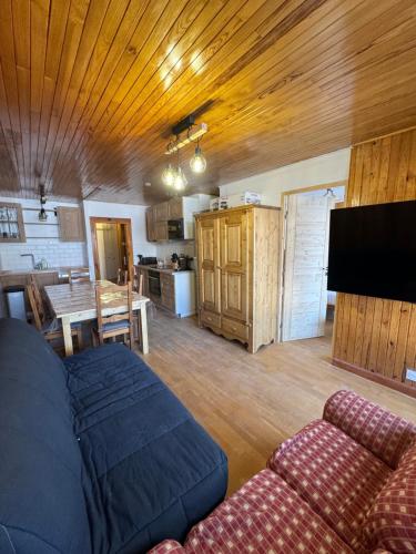 a living room with a couch and a dining room at Appartement Tignes - Quartier Calme - 2 chambres - 3 Télévisions - Netflix & Wifi inclus in Tignes