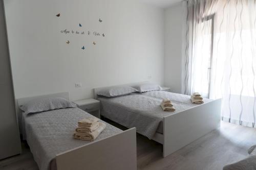duas camas num quarto branco com toalhas em BnB Martin em Jesolo
