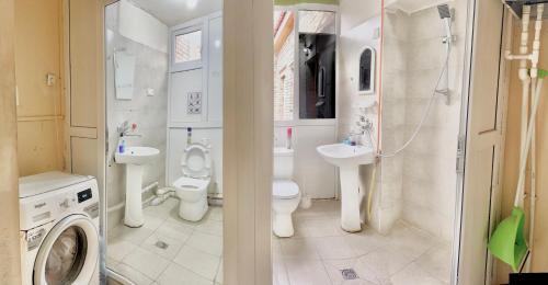 a bathroom with two toilets and a sink and a washing machine at Hello Fox GuestHouse in Tbilisi City