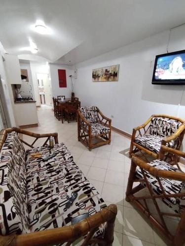 Zimmer mit Stühlen und einem Flachbild-TV in der Unterkunft Atacames Hermosa Vista y Comodidad in Atacames