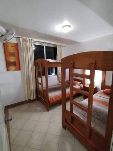 a bedroom with two bunk beds and a window at Atacames Hermosa Vista y Comodidad in Atacames