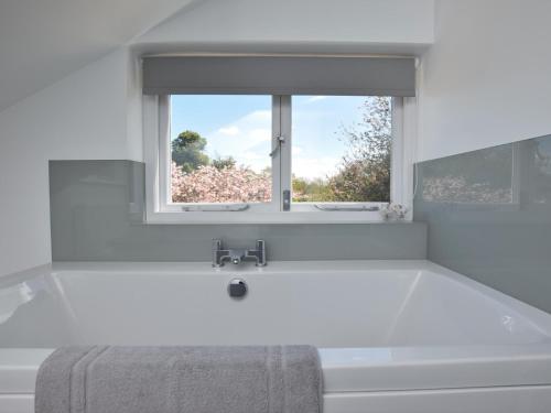 a bath tub in a bathroom with a window at 5 Bed in Wroxham 56103 in Hoveton