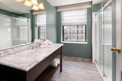 a bathroom with a large sink and a shower at Landmark Inn in Marquette