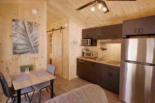a kitchen with a refrigerator and a table with chairs at Nordique spa Stoneham in Stoneham