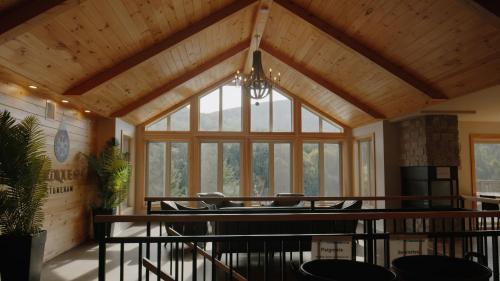 a room with a wooden ceiling with a large window at Nordique spa Stoneham in Stoneham
