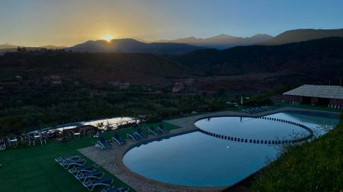 a view of a pool with chairs and the sunset at Panorama Complex in Tahannout