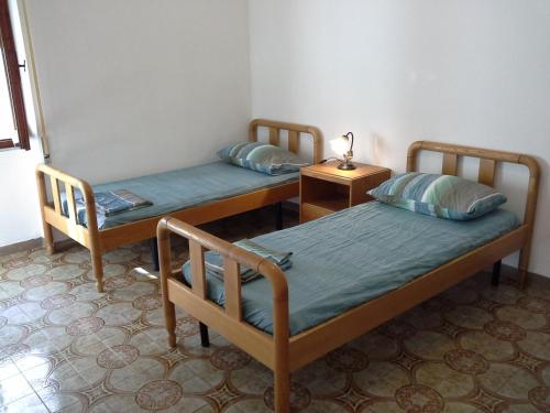 アルゲーロにあるBarbagia Apartmentのベッド2台、テーブル(ランプ付)が備わる客室です。