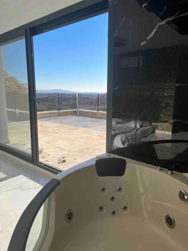 - une baignoire blanche dans une chambre avec fenêtre dans l'établissement Villa contemporaine près des gorges de l’Ardèche, à Pont-Saint-Esprit