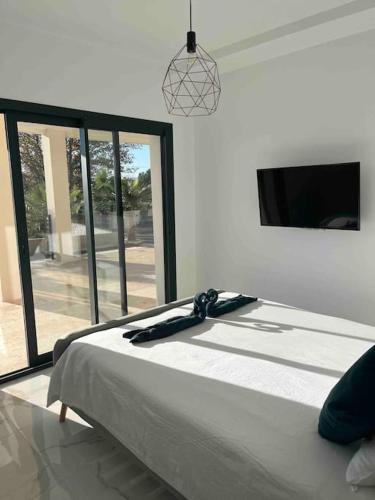 une chambre avec un grand lit et une grande fenêtre dans l'établissement Villa contemporaine près des gorges de l’Ardèche, à Pont-Saint-Esprit