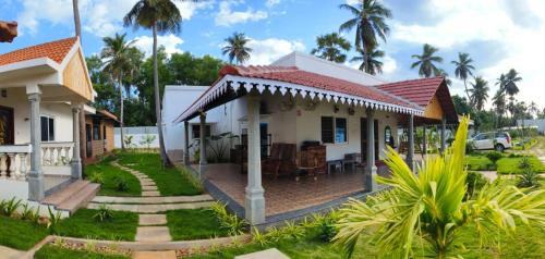 a house with a garden and palm trees at Athulya Resort -Leisure and Luxury cottages from EMBEHolidays in Kottaikadu