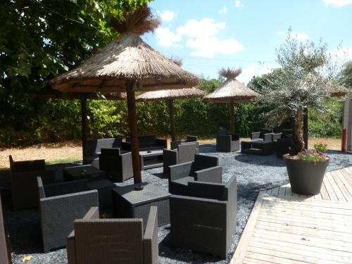 a group of chairs and umbrellas in a yard at Ambiance Hotel in Limas