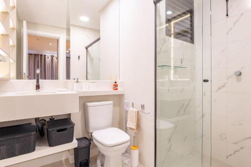 y baño con aseo y ducha acristalada. en Loft de Luxo para até 4 pessoas em Bombas - Condomínio com Piscina, en Bombinhas