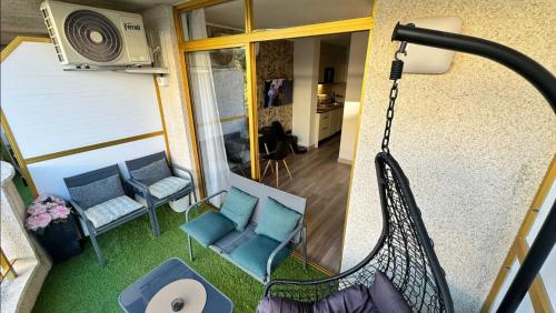 a balcony with a swing and chairs and a room at A ESTRENAR PRECIOSOS APARTAMENTOS APARTHOTEL INTER2, NEW APARTMENTS lN APARTHOTEL 12 months open! self check in! RESERVA Garaje! in Salou
