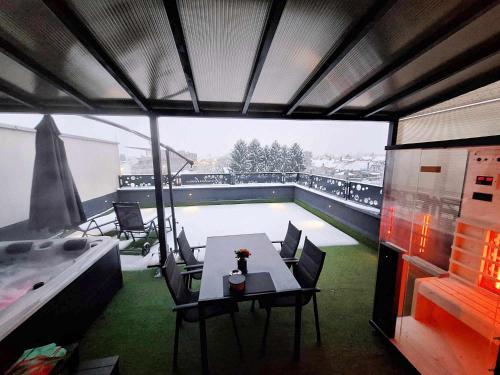 un patio con tavolo, sedie e piscina di Arcobaleno Apartments & Rooms a Varaždin