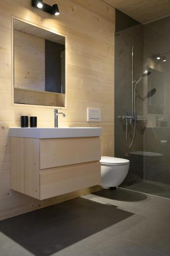 a bathroom with a sink and a toilet and a shower at Mondholz Ferienwohnung in Andermatt
