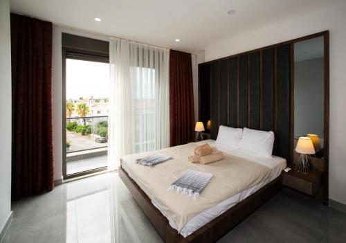 a bedroom with a large bed with a large window at Living Dream Apartment DUPLEX BELEK in Belek