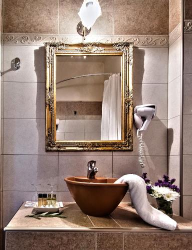 a bathroom with a wooden sink and a mirror at Hotel Doupiani House in Kalabaka