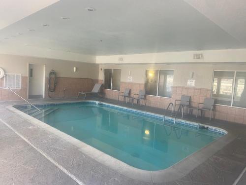 a large pool in a hotel with chairs and tables at Baymont by Wyndham Springfield I-44 in Springfield