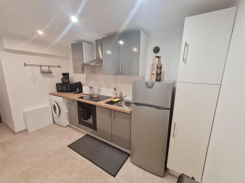une cuisine avec un réfrigérateur et un lave-vaisselle dans l'établissement Appartement Vacances ZEN, à Fréjus
