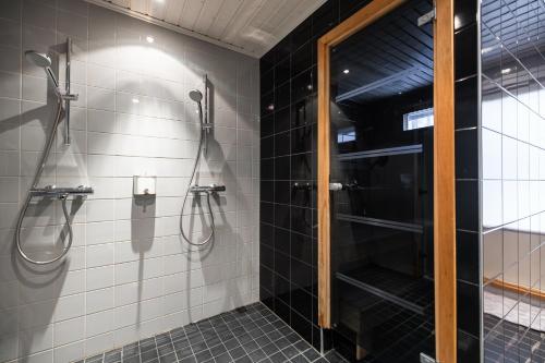 bagno con doccia e piastrelle bianche e nere di Arctic River House a Rovaniemi